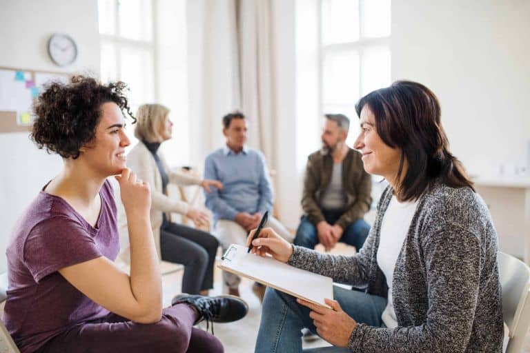 woman talks to counselor during group therapy at IOP