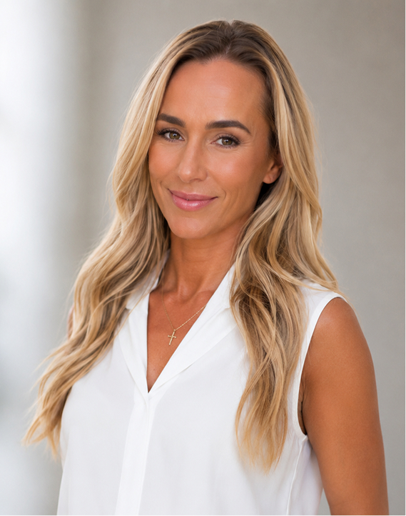 Professional woman with long blonde hair in white sleeveless top at Inner Voyage Recovery Center.