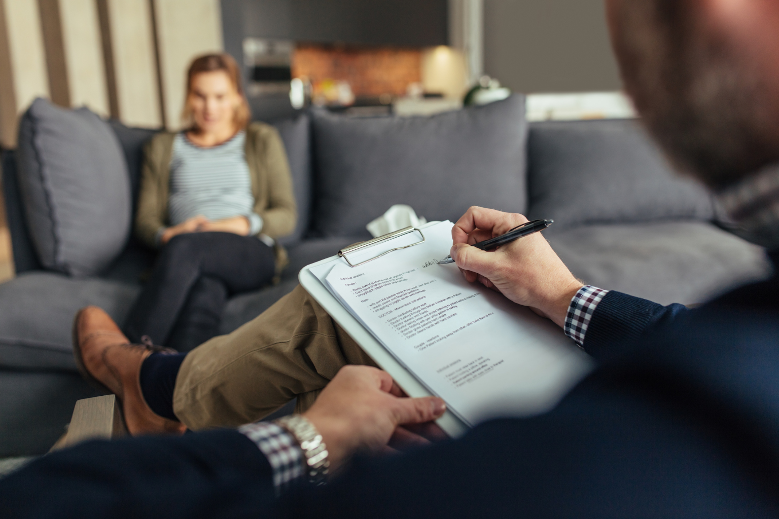 Therapist conducting a counseling session with a patient in a cozy office setting.