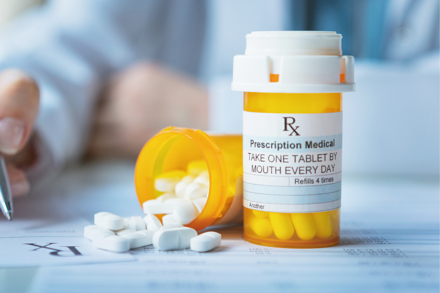 Prescription medication bottle with pills on a medical table in a healthcare setting.
