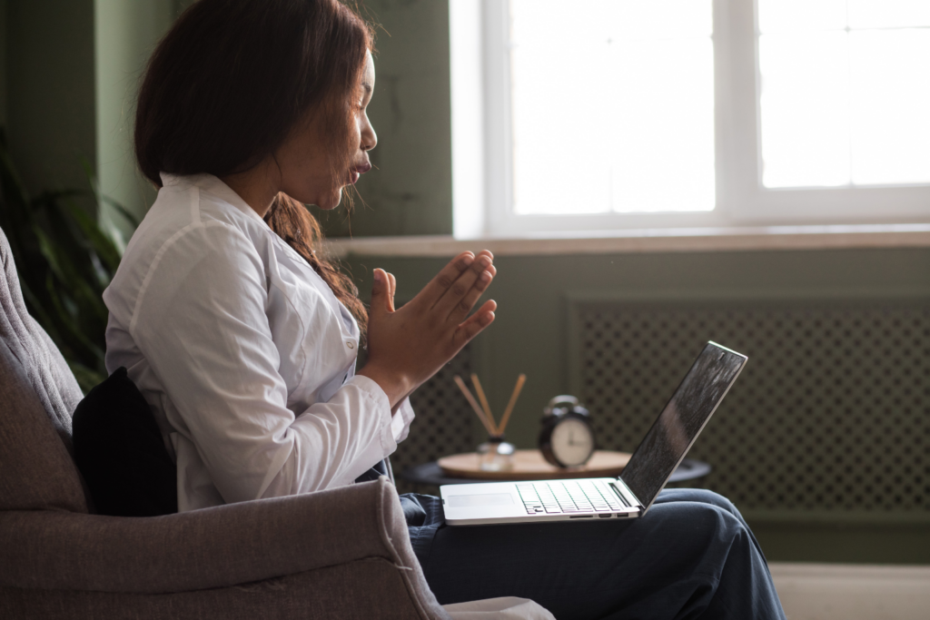 Woman in prayer during telehealth substance abuse treatment session at Inner Voyage Recovery.